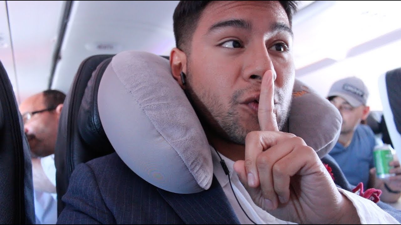 latino man wearing a travel neck pillow - dandy in the bronx - travel pillow - neck pillow