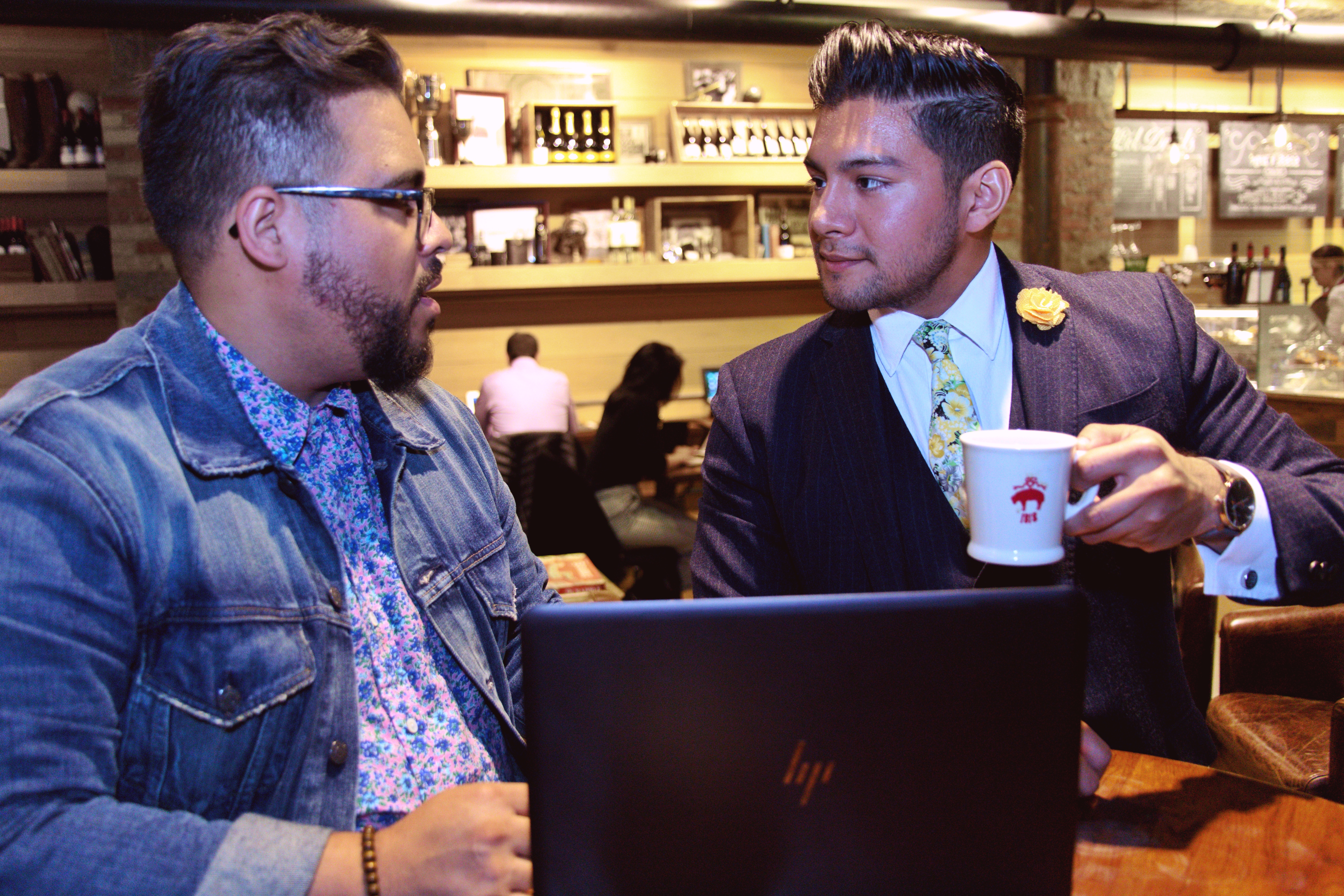 Professionalism In Business Comes In Many Forms - two Latino men talking about business with a laptop - dandy in the bronx