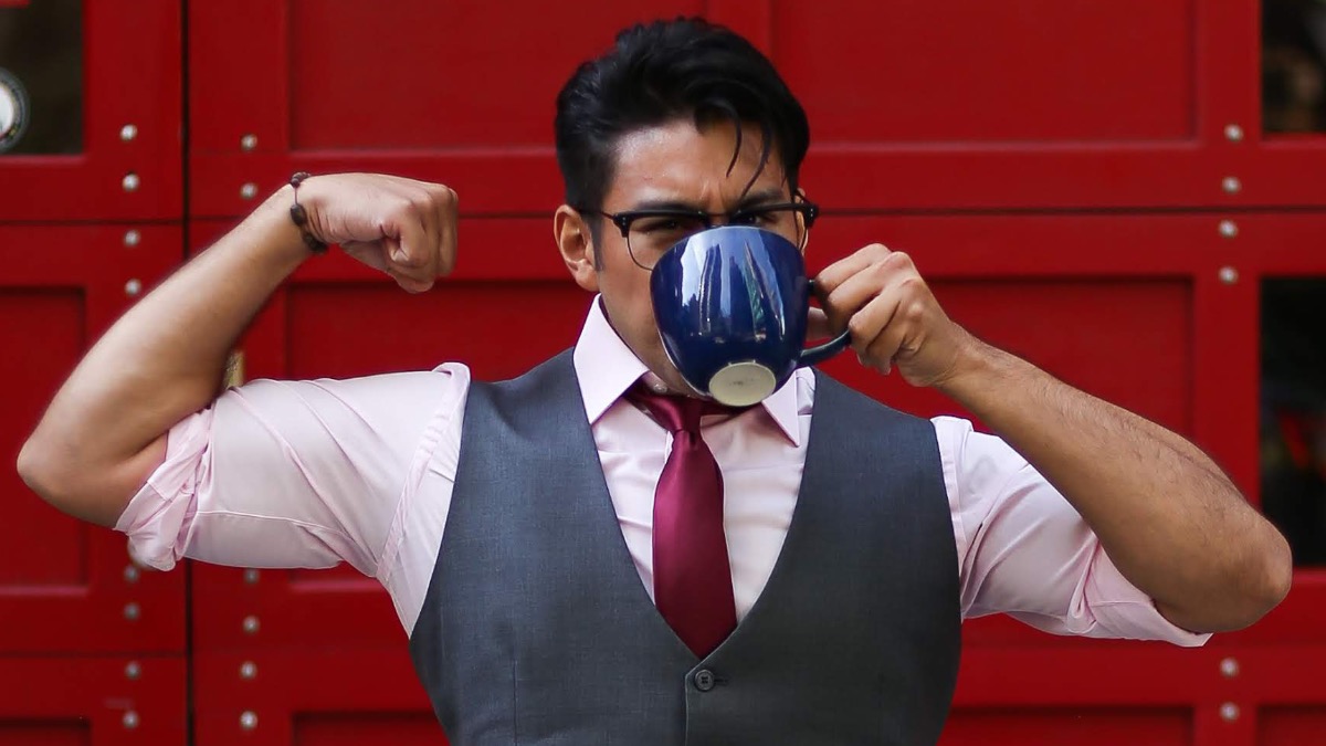 man with glasses flexing while drinking coffee - dandy in the bronx