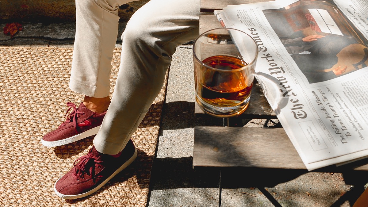 A GENTLEMAN KNOWS HOW TO BEHAVE THE DAY AFTER A PARTY - khaki pants - burgundy sneakers - whisky - newspaper - dandy in the bronx