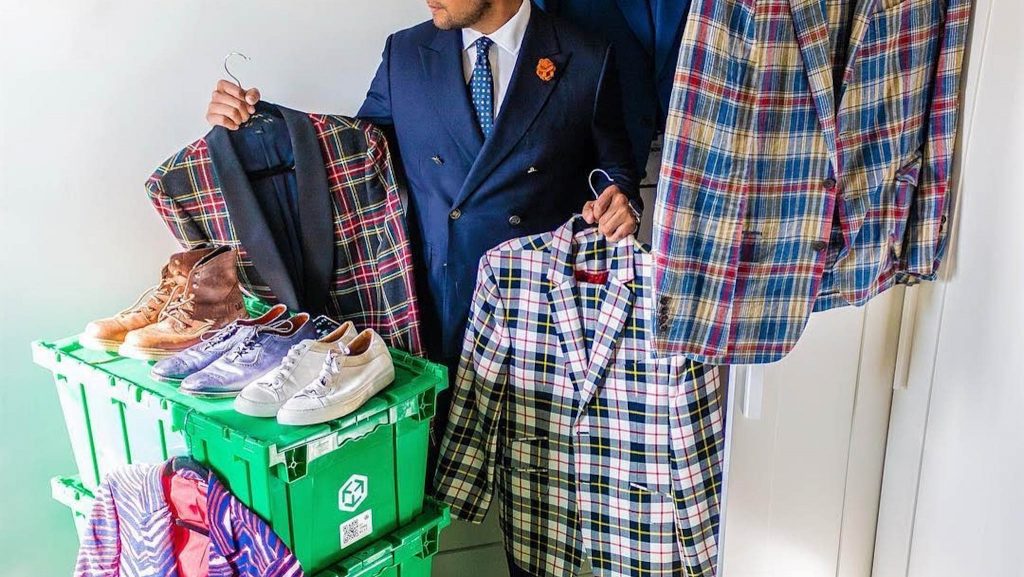 Man surrounded by suits - man in navy suit - man in navy double breasted suit - plaid suits - dandy in the bronx