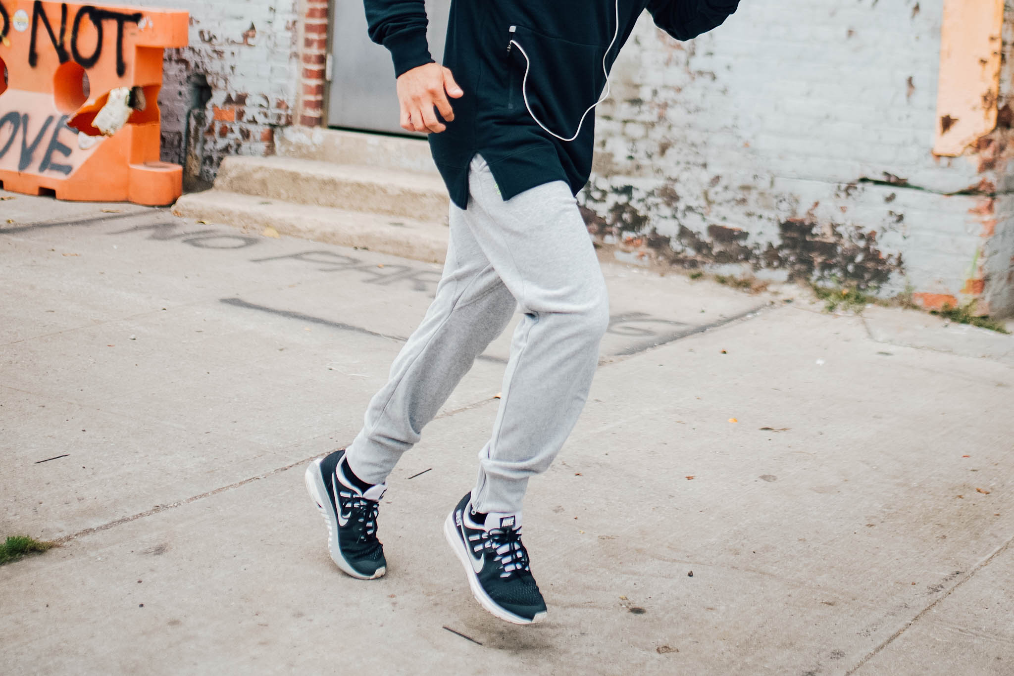 man in gym clothes - man in running clothes - man wearing grey joggers - grey sweat pants - black hoodie - black Nike sneakers - man running